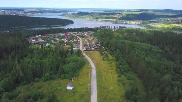 森とフィールドを介して空中村道路 森の中の村に通じる道 航空写真ビュー — ストック動画