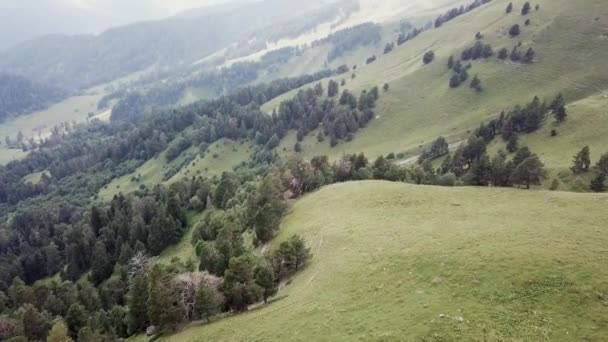 緑の草で覆われた岩が多い丘の上のフライト 高山美しい雲の上空 — ストック動画