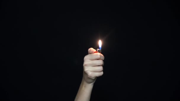 手拿着一个燃烧的打火机的特写 在黑色背景上被隔离 — 图库视频影像