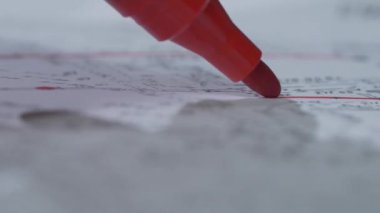 Kırmızı bir işaretleyici bir yaprak kağıda yazar. Yakın çekim. Marker ucu. Gölge 4k ile kırmızı işaret