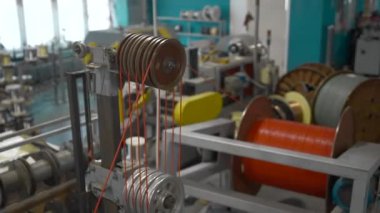 Bobinleri ve kabloları olan dönen bir endüstriyel makine. Yaratıcı. Endüstriyel fabrikada dönen makinelerle atölye çalışması
