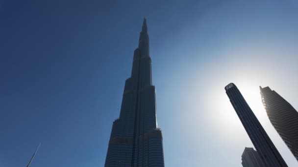 阿拉伯联合酋长国迪拜市的Burj Khalifa 蓝色晴朗的天空映衬着一座巨大的摩天大楼的低角度视图 — 图库视频影像