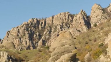 Dağlar tepeler geç sonbaharda üzerinde yeşil küçük ağaçları ile güzel manzara. Güzel, sıradışı kayalar ve solmuş sonbahar günbatımı çalıların