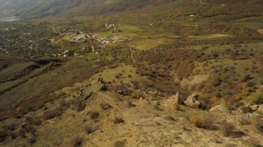 Hava alp manzara mavi gökyüzü ve sonbahar sarı çim ile dağlarda küçük bir köy. Bir köyün bir vadide Alpleri'nde renkli sonbahar sahne.