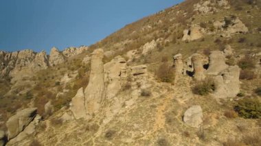 Güzel sonbahar manzara alışılmadık kayalar ve güneşli bir gün tepelerde. Tuhaf formu tepeler üzerinde dağlarla solmuş, sarı tepeler arka plan.