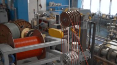 Bobinleri ve kabloları olan dönen bir endüstriyel makine. Yaratıcı. Endüstriyel fabrikada dönen makinelerle atölye çalışması