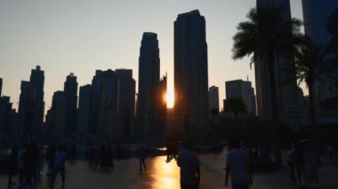 Gökdelen kuleleri ve tanınmayan kalabalık arasında gün batımı. Başla. Dubai 'nin merkez bölgesi.