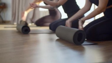 Pilates yapmaya başlamak için kadın spor gruplarının paspaslarını kapatın. Medya. Zeminde egzersiz ve fitness başlatılıyor 