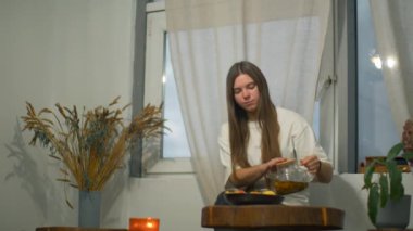 Genç bir kadın kafede romantik bir şekilde çay içer. Medya. Genç kız öğrenci kafede çayla dinleniyor. Güzel, genç bir kadın, rahat bir kafede tek başına çay içiyor.. 