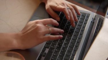 Dizüstü bilgisayarda yazan güzel bir kadının yakın çekimi. Stok görüntüleri. Güzel kadın elleri dizüstü bilgisayarda klavye kullanıyor. Kadın serbest çalışan, kafede dizüstü bilgisayarda çalışıyor.. 