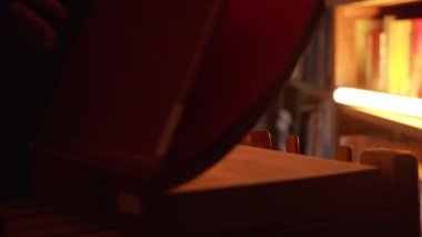 Büyük kitabı açan gizemli adamın yakın çekimi. Stok görüntüleri. Adam karanlık kütüphanede parlayan ışıkla kitabı açıyor. Gece kütüphanesinde gizemli kitapları olan gizli bir topluluk.. 