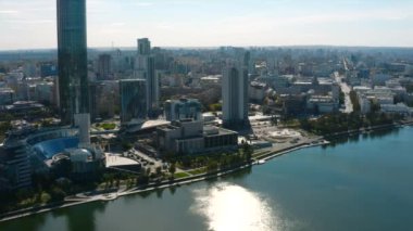 Güneşli bir yaz gününde modern şehrin en güzel manzarası. Stok görüntüleri. Nehirde modern şehrin modern cam binaları olan yüksek binalar. Yüksek binaları ve nehri olan güzel modern şehir.