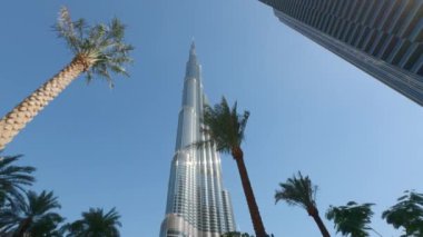Burç Halife Dubai şehrinde, Birleşik Arap Emirlikleri. Başla. Dev bir gökdelen ve palmiye ağaçlarının alçak açılı görüntüsü