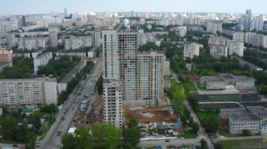 Şehirdeki çok katlı binanın en üst manzarası. Stok görüntüleri. Yaz günü şehir merkezindeki çok katlı binanın inşaatı. Modern şehrin gökdelenli manzarası