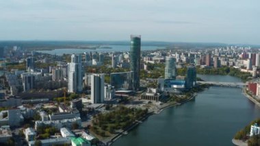 Nehirli güzel şehir manzarası. Stok görüntüleri. Güneşli bir günde gökdelenleri ve nehri olan güzel şehir manzarası. Gelişmiş altyapısı olan güzel ve modern şehirde yaz mevsimi. 