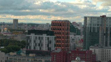 Modern binaların ve şehrin ön cephelerinin en üst görüntüsü. Stok görüntüleri. Modern yüksek binalar arasındaki güzel şehir manzarası. Arka planda yeşil manzaralı modern şehrin güzel binaları. 