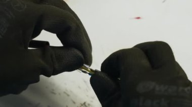 Lehim demiri, kablo tamiri. Yaratıcı. Endüstriyel arka planda koruyucu eldivenli bir işçinin kablo onarımını kapatın.