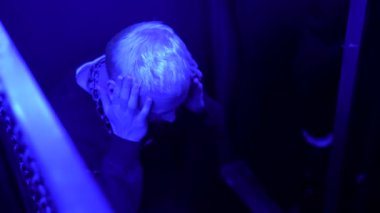 Gece kulübündeki boynunda metal zincir olan sarhoş adamın yardıma ihtiyacı var. Medya. Alkol ve uyuşturucu kullanımı kavramı 