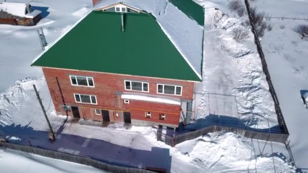 冬の村の空中ビュー 田舎の詳細 クリップ 赤レンガのコテージと小さな家 雪が覆われた地面 — ストック動画