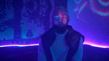 Neon ışıklı odada bir adam var. Medya. Adam evde neon partisinde tek başına müziğin tadını çıkarıyor. Adam ev yapımı neon partisinde dans ediyor. Hippi partileri.