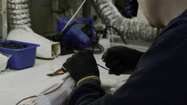 Elektrik telleriyle çalışan usta bir elektrikçi. Yaratıcı. Atölye ve ekipman detayları