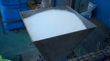 Elektronik cihaz koruması için polimer silis jel kurutucu. Yaratıcı. Fabrikadaki beyaz küçük toplarla dolu konteynırı kapatın.