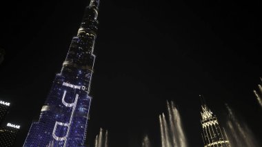 DUBAI - BAE, UAE, 3 Nisan 2023: Burj Khalifa yakınlarındaki Dubai alışveriş merkezinde dans eden çeşmeler. Başla. Popüler turizm bölgesinde gece güzel bir şelale gösterisi