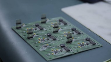 Servis merkezinde bilgisayar parçaları tamir eden genç bir adam. Yaratıcı. Çipi lehimlemeye yakın tut.