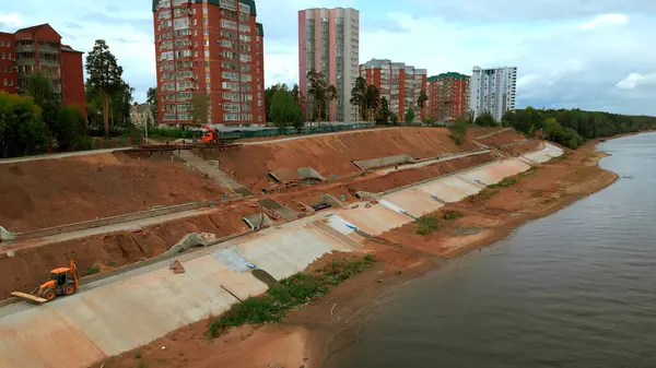 stock image Aerial view of construction site on city embankment next to the river. Clip. Process of improving pedestrian road