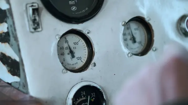 Switches and gauges inside the cabin of an old ship. Clip. Close up of blurred captain hand on wheel and dash board