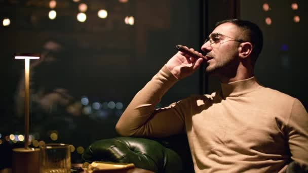 商人在餐馆里抽烟雪茄 男人晚上在豪华餐厅抽烟 优雅的男人在夜店抽烟 — 图库视频影像