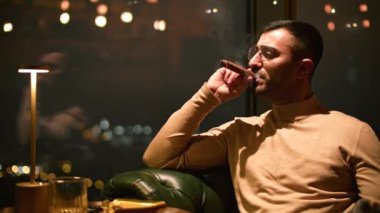 İş adamı restoranda puro içer. Medya. Adam gece lüks restoranda puro içiyor. Zarif adam akşam restoranında puro içiyor.. 