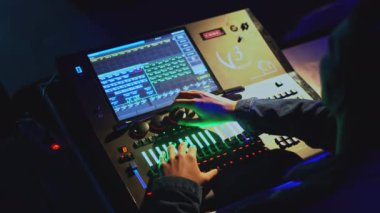 Işık konsolu kontrolü. Medya. Adam tiyatroda ışık ve ses kontrol panelinde joystickleri hareket ettiriyor. Tiyatroda modern ses ve ışık kontrol konsolu.