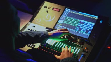 Işık konsolu kontrolü. Medya. Adam tiyatroda ışık ve ses kontrol panelinde joystickleri hareket ettiriyor. Tiyatroda modern ses ve ışık kontrol konsolu.