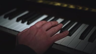 Piyano çalmaya yakın plan. Medya. Parmaklar piyano tuşlarında zarifçe çalar. Güzel piyano klavyesi çalıyor. 