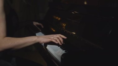 Piyano çalan kadının yakın çekimi. Medya. Zarif bir kadın hızlandırılmış ritimle piyano çalar. Piyano çalan kadının hızlandırılmış videosu. 