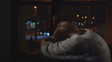Depresyondaki kadın evin penceresinden dışarı bakıyor. Medya. Anksiyete bozukluğu olan bir kadın ata biner ve üzülür. Kazaklı kadın pencerede yalnız oturuyor.. 