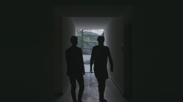 Two Male Silhouettes Walking Dark Long Hotel Corridor Stock Clip — ストック動画
