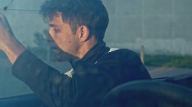 Genç adam mekanik pencere kaldırıcısını çeviriyor ve söküyor. Hisse. Kırıldıktan sonra Cabriolet vagonundan çıkan adam.