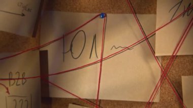 Kırmızı iplikli notlar. Stok görüntüleri. Kırmızı iplikle birbirine bağlanmış gizemli notların yakın çekimi. Gizemli tahtada iplikli semboller ve bulmacalar.