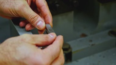 Çalışan ellerin, endüstriyel makinede işlemek için küçük metal fayanslar koyması. Stok görüntüleri. Atölyenin ayrıntıları