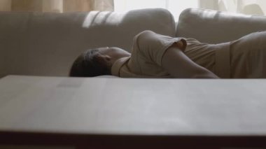 Kadın uyurken telefonu alan adam. Hisse. Adam öldürülen kadının telefonunu alıyor. Kadın öldürülmüş gibi kanepede yatıyor ve biri telefonunu alıyor. Cinayet, dedektif, suç, drama.. 