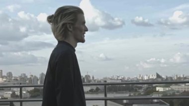 Genç adam binanın çatısında. Hisse. Genç adam binanın çatısındayken garip davranıyor. Yazın yüksek binaların terasındaki adam.. 