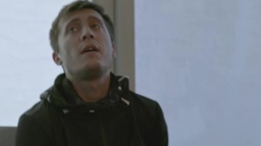 Yansımalı odaya bakan adamın yakın çekimi. Hisse. Duyguları olan bir adam çalışmak için yeni bir oda arar. Adam odaya panoramik pencerelerle ve hayran olunan iç mekanıyla girdi.. 