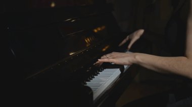 Piyano çalan kadının yakın çekimi. Medya. Zarif bir kadın hızlandırılmış ritimle piyano çalar. Piyano çalan kadının hızlandırılmış videosu.
