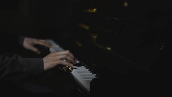 Крупный план мужских рук, играющих на пианино. СМИ. Красивые руки играют мелодию на пианино. Мужские руки играют на пианино.