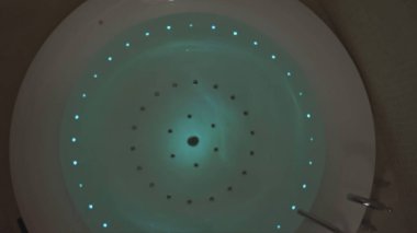 Jakuzinin rengini değiştiriyorum. Hisse. Jakuzide suyun altında ışık değiştirmek. Jakuzi ile akşam rahatlaması için spa.