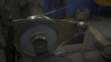 Kabloyla Endüstriyel Döndürme Makinesi. Yaratıcı. Dönen bobinler fabrikada kabloyu sarar. Metalürjik üretim makinelerinde tel döşeyen endüstriyel atölye.