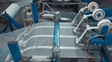 Otomatik Polymer Ağ Makinesi. Yaratıcı. Makineler polimer ızgaraya ısıtma kabloları döşüyorlar. Zemin ısıtması için endüstriyel modül üretimi.