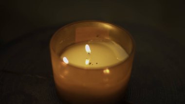 Sıcak mum alevinin yakın çekimi. Medya. Sıcak ve spa atmosferi yaratan bir mum. Sıcak ışık ve kaplıcada güzel kokulu Aroma mumu.